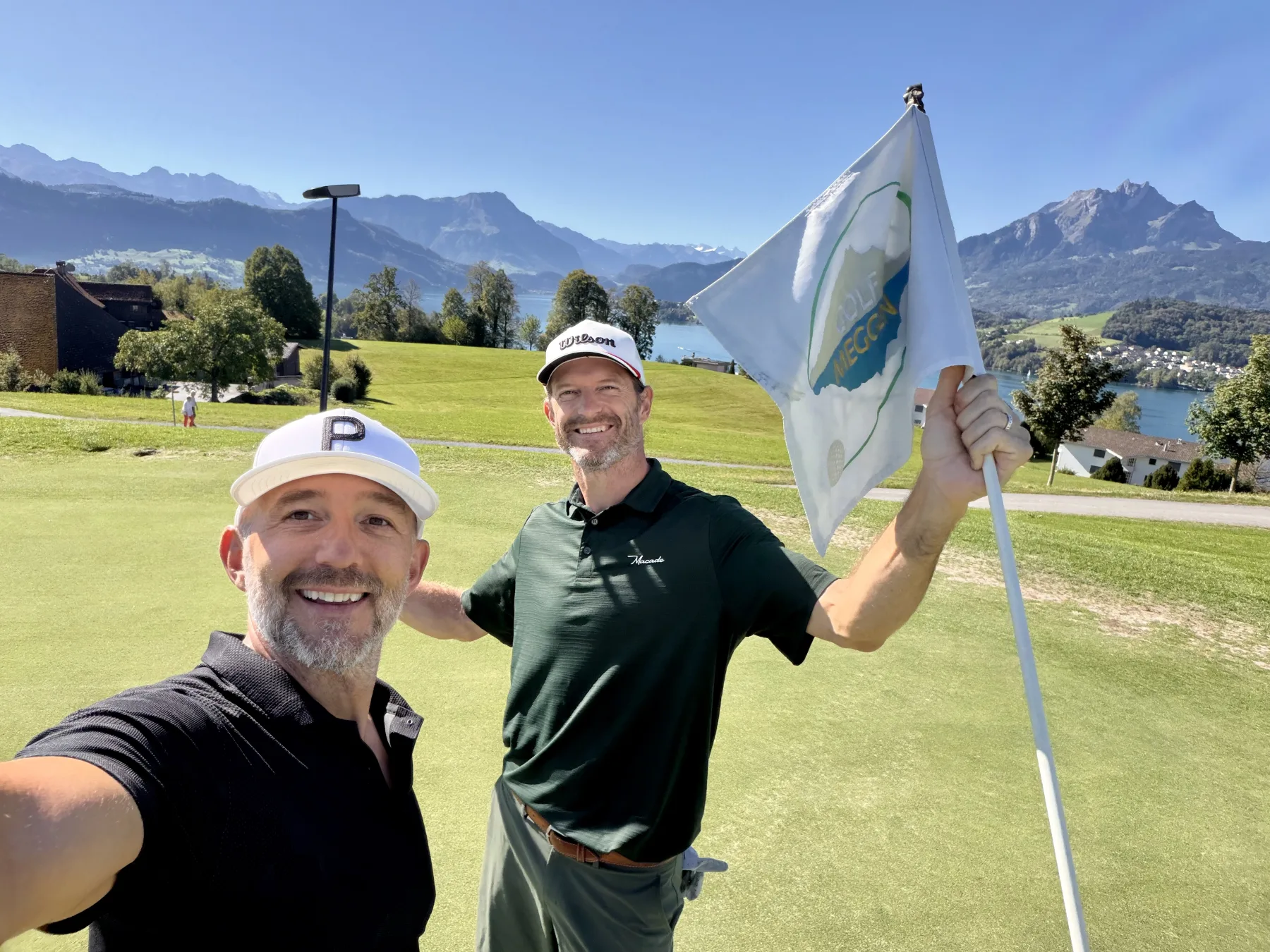 Yves with a client on the green at Golf Meggen, Lake Lucerne behind